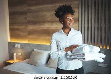 Maid with fresh towels in hotel room. Fresh towels during housekeeping in a hotel room. Maid with fresh clean towels during housekeeping in a hotel room. - Shutterstock ID 2113625102