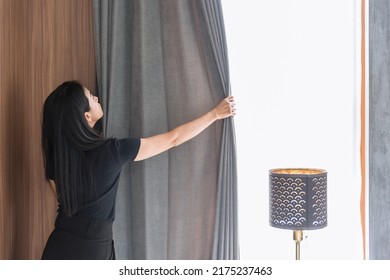 Maid housewife woman working chores housekeeping cleaning room arrange window curtains at home or hotel. - Shutterstock ID 2175237463