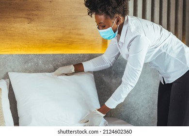 Maid Wearing Mask Cleaning Bedroom After Guests In Hotel Room. Hotel Service Concept. Maid Working At A Hotel Doing Room Service And Disinfecting Due To COVID-19 Pandemic