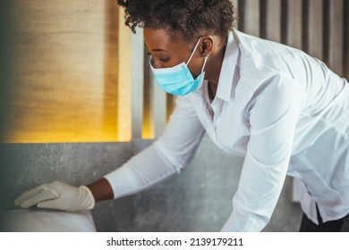 Maid Wearing Mask Cleaning Bedroom After Guests In Hotel Room. Hotel Service Concept. Maid Working At A Hotel Doing Room Service And Disinfecting Due To COVID-19 Pandemic