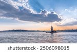 Maidens tower before sunset with colorful clouds and rays of sun light timelapse in Istanbul, turkey, kiz kulesi tower. City skyline on background with reflection on Bosforus water