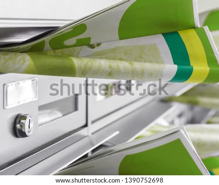 Mail boxes filled of leaflets. Many flyers in mailboxes, symbol for advertising, marketing, spam.