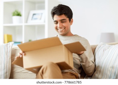 Mail Delivery, Shipment And People Concept - Happy Man Opening Parcel Box At Home