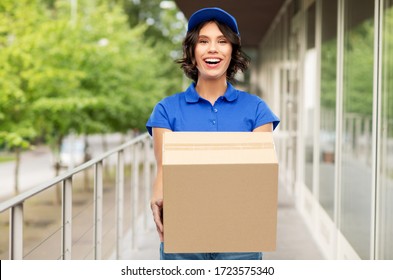 Mail Service And Shipment Concept - Happy Smiling Delivery Girl With Parcel Box In Blue Uniform Over City Street Background