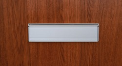A Mail Slot On A Wooden Door