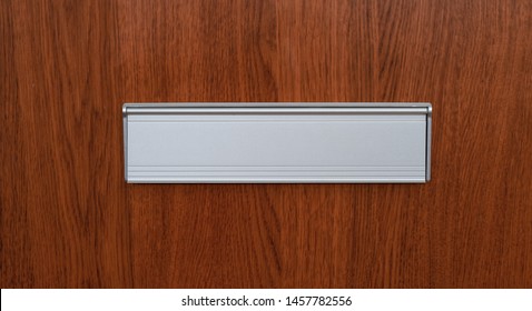 A Mail Slot On A Wooden Door