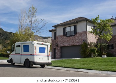 Mail truck makes a stop in a residential neighborhood.
