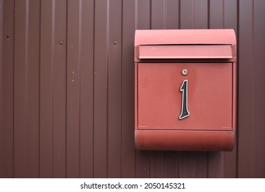 A Mailbox With The Number One Attached To A Metal Fence