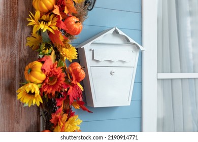 Mailbox On Wall At Entrance Of House. White Mailbox In Front Of Home. Entrance Of House Door Decorated With Autumn Leaves For Holiday. Fall Festive Yellow Leaf, Twigs And Pumpkins On Facade Home. 
