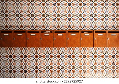 Mailboxes for letters at the entrance of the residential building of a community of neighbors with a background of geometric tiles of Andalusian style, Spain