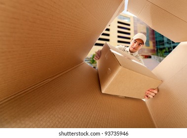 Mailman Delivering A Package Inside A Mailbox