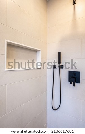 Main bathroom home renovation, modern bathtub, walk-in shower, ceramic tiles with black fixtures.