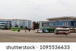 the main bus station in Wonsan, in southern North Korea, a few buses are waiting in the front of the station, in the foreground two propaganda minibuses                  