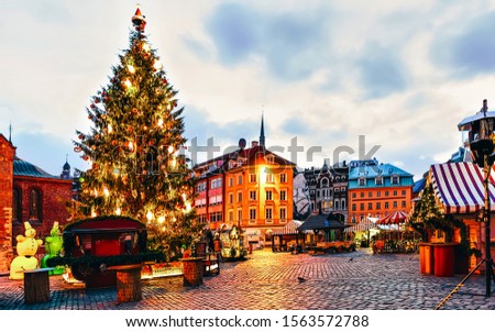 Main Christmas tree located at the Dome square in Christmas market in winter Riga in Latvia. Street Xmas and holiday fair in European city Advent Decoration and Stalls with Crafts Items on Bazaar