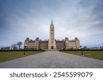 Main clock tower of center block of Parliament of Canada, in Canadian Parliamentary complex of Ottawa, Ontario, containing Senate  house of commons on a cloudy afternoon.