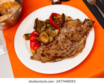 Main course for lunch - roast beef with roasted vegetables - complemented by olives, glass of red wine and bran bread - Powered by Shutterstock