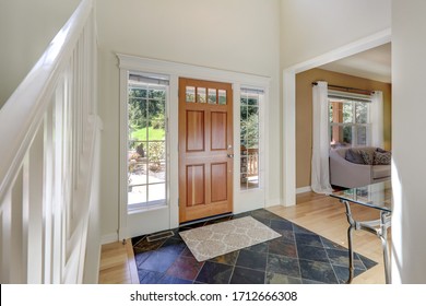 Main Door Entrance Hallway With Wooden Door And Natural Stone Dark Tiles.