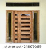 a main door that has not been painted and shows the original wood grain with glass in the middle