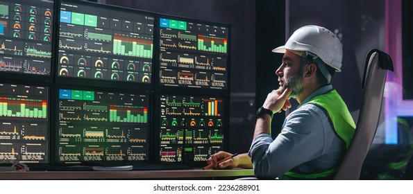 Main engineer following the plant process using Industry 4.0. Operator control process of production uses computer screens with SCADA system  - Shutterstock ID 2236288901