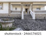 Main facade of chalet with plot with granite stone floors and access staircase with white cement balustrades
