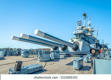 Main Gun On USS North Carolina Battleship Under Blue Sky Background.