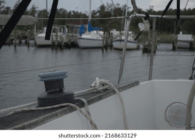 Main Jib Sheet Winch On A Sailboat Moored In A Marina.  Sail And Powerboats Are Seen In The Background.