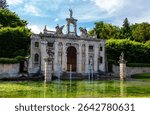 Main portal of the Diana fountain in Villa Barbarigo Valsanzibio Galzignano, Padua. Detail of the door that is reflected in pond with beautiful water lilies and its monumental garden 