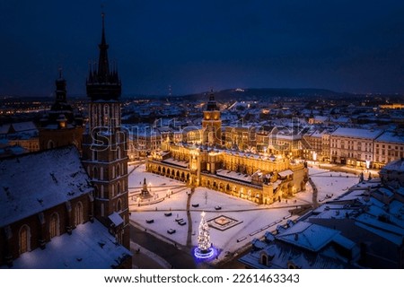 Main Square (Saint Mary's Basilica, Sukiennice - Cloth Hall, Town Hall Tower) in Krakow during blue hour at magic dusk during Christmas time and winter, Poland