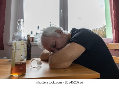 The Main Subject Is Out Of Focus, Old Senior Male Man Sit Next To Table Drink Alcohol Bottle At Home Sad Alone Alcoholism Signs And Symptoms Rehab Abuse And Recovery Problems