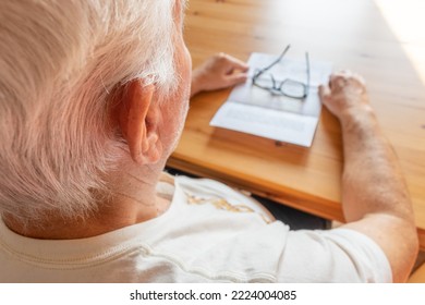 The Main Subject Is Out Of Focus , Senior Old Male Man Sit Table Pay Bills Read Letter, No Money, Thinking.