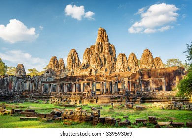 Main view of ancient Bayon temple in Angkor Thom in evening sun. Mysterious Angkor Thom nestled among rainforest in Siem Reap, Cambodia. Enigmatic Angkor Thom is a popular tourist attraction. - Powered by Shutterstock