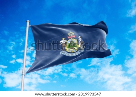 Maine flag waving in the wind, blue sky background