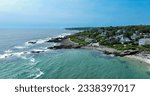 Maine rocky coast with crashing waves and aerial view of marginal way running and walking path.