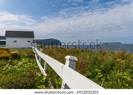 Mainland (La Grand'terre) coast line on Port au Port Peninsula in Newfoundland, Canada. Red Island (L'Île Rouge), Sisters’ Dream School Museum, white fence, 
