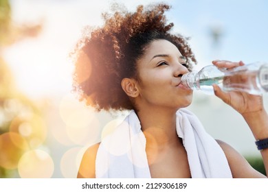 Maintaining good hydration also supports healthy weight loss. Cropped shot of a young woman enjoying a bottle of water while out for a run. - Powered by Shutterstock