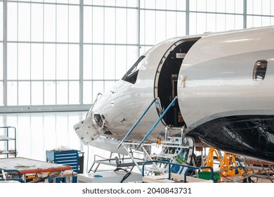 Maintenance Of Airplane In The Large White Hangar. Jet Flight Service. Private Airplane At The Service Park 