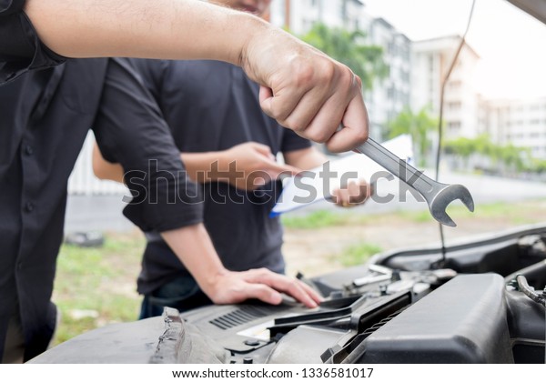 Maintenance car repair\
automotive concept, Man checking car mechanic working  under car\
hood in garage.