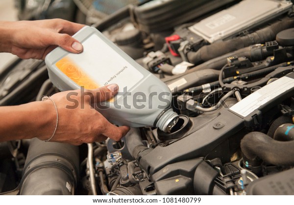 Maintenance car repair automotive worker with\
changing the oil