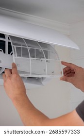 Maintenance Complete. Technician Installing Clean Air Filter in Air Conditioner.