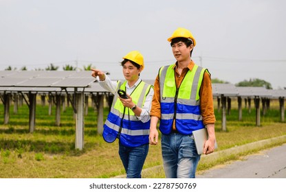 Maintenance engineer checking and maintaining solar panels on solar cell farm