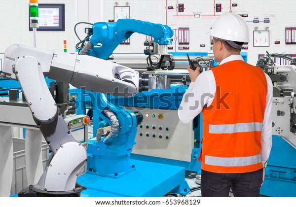 Maintenance\
engineer control automatic robotic hand machine tool at industrial\
manufacture factory, Industry 4.0\
concept