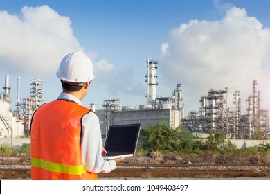 Maintenance engineer working with laptop in oil refinery