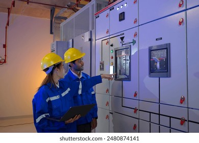 Maintenance engineers are checking electronic system at basement building. Blue collar worker and engineer.