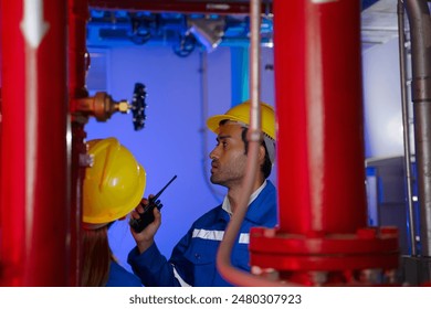 Maintenance engineers are checking water system at basement building. Blue collar worker and engineer.