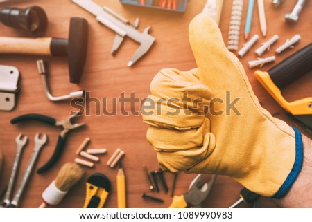 Maintenance handyman gesturing thumb up approval hand sign over the work desk with DIY tools, top view