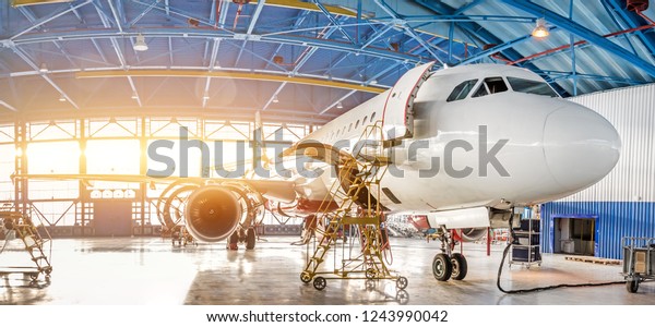 Maintenance and repair of aircraft in\
the aviation hangar of the airport, view of a wide\
panorama