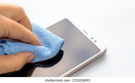 maintenance and repairing smartphones. hand is cleaning phone screen with blue napkin. many tempered glass screen protector.  mobile screen replacement protector. installation of protective cover film - Shutterstock ID 2153526093