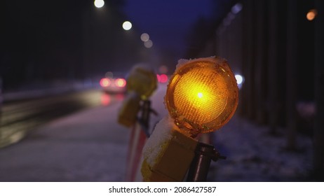 Maintenance Roadworks Barrier Orange Caution Lamps Blinking in Sequence by Busy Icy Road with High Congestion Traffic on Winter Evening