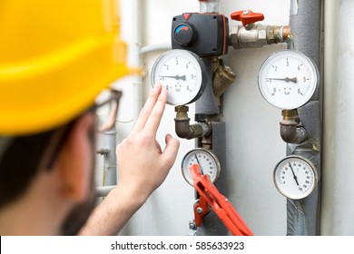 maintenance - technician checking pressure meters for house heating system