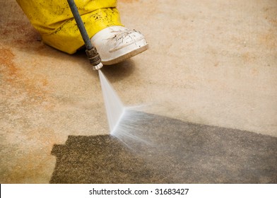 Maintenance Worker Cleaning Old Dirty Driveway With A Pressure Cleaner